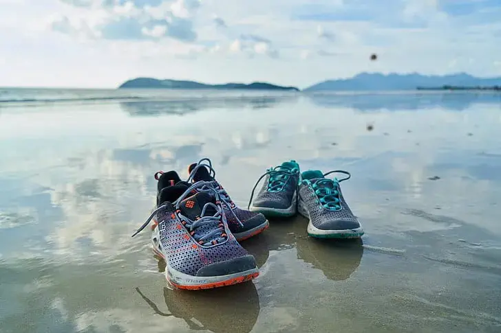 Running shoes on an empty road into the horizon.